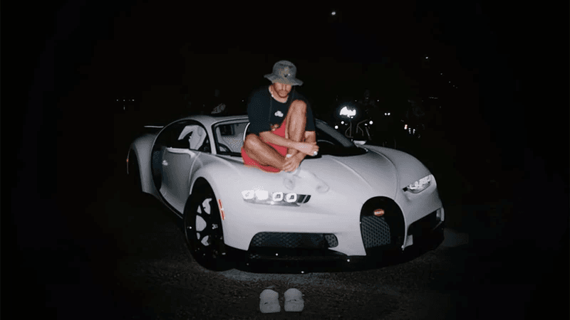 Bad Bunny sitting on top of a Buggati car